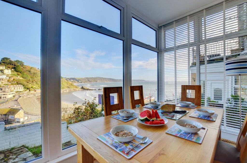 a dining room with a table with a view of the ocean at The Gulls in Looe