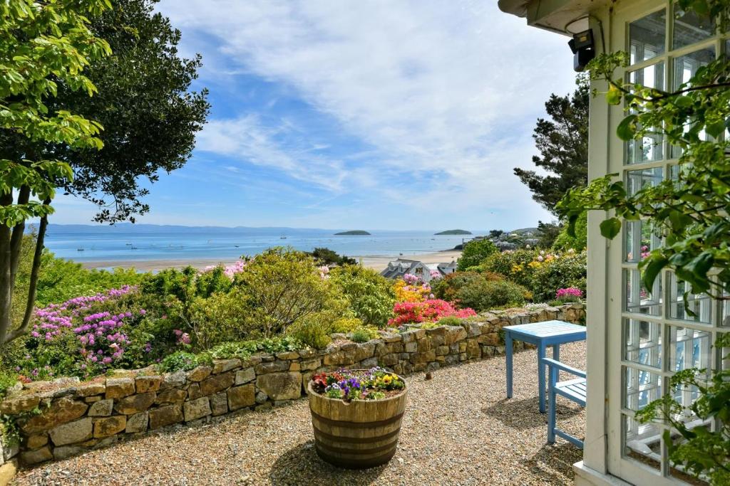 a window view of the ocean from a house with flowers at Trefaes in Abersoch