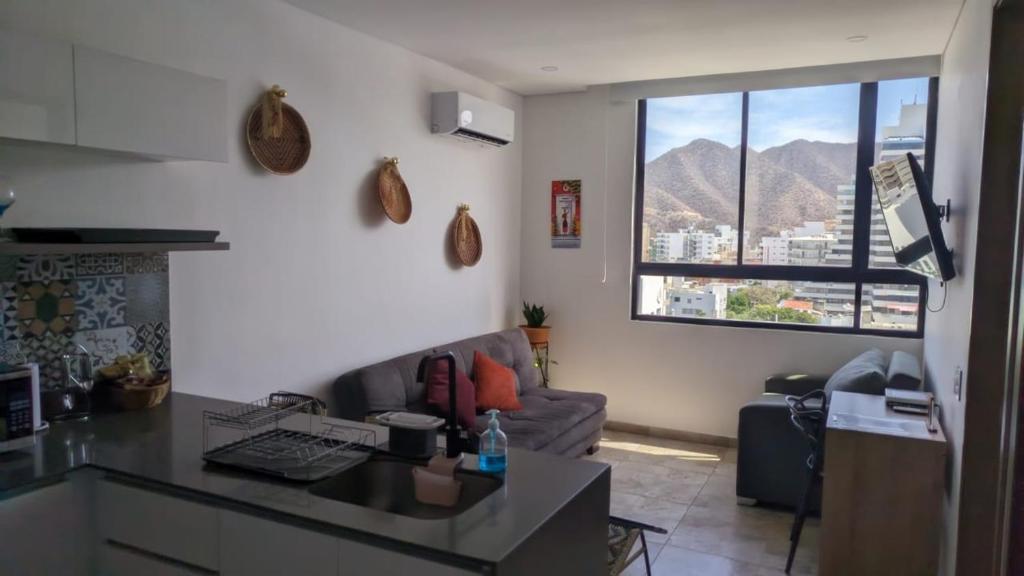 a kitchen and living room with a couch and a window at Vita905 RODADERO in Santa Marta