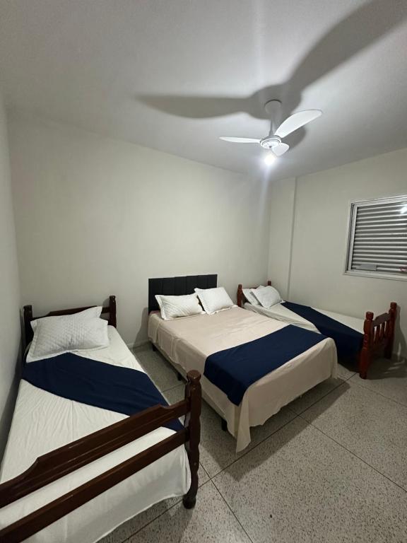 プライア・グランデにあるApto completo com vista pro marのベッド2台と天井ファン付きの寝室