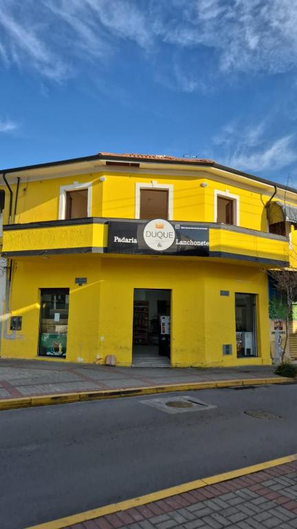 a yellow building on the side of a street at Hotel Brasil in Piquete