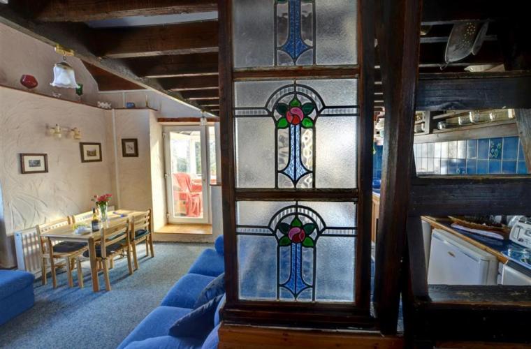 a living room with a blue couch and stained glass at 3 Bed in Llanfairpwllgwyngyll oc-wai194 in Dwyran
