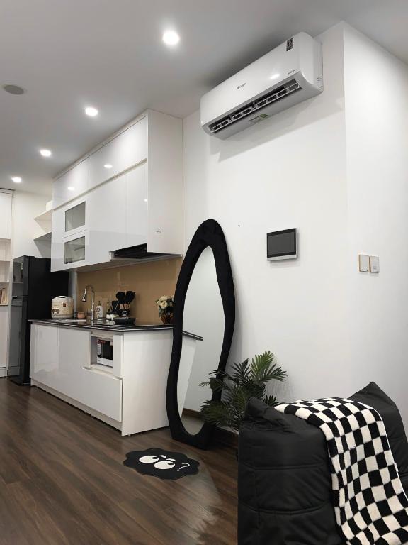 a living room with a kitchen with a black and white at Romaji House in An Khê