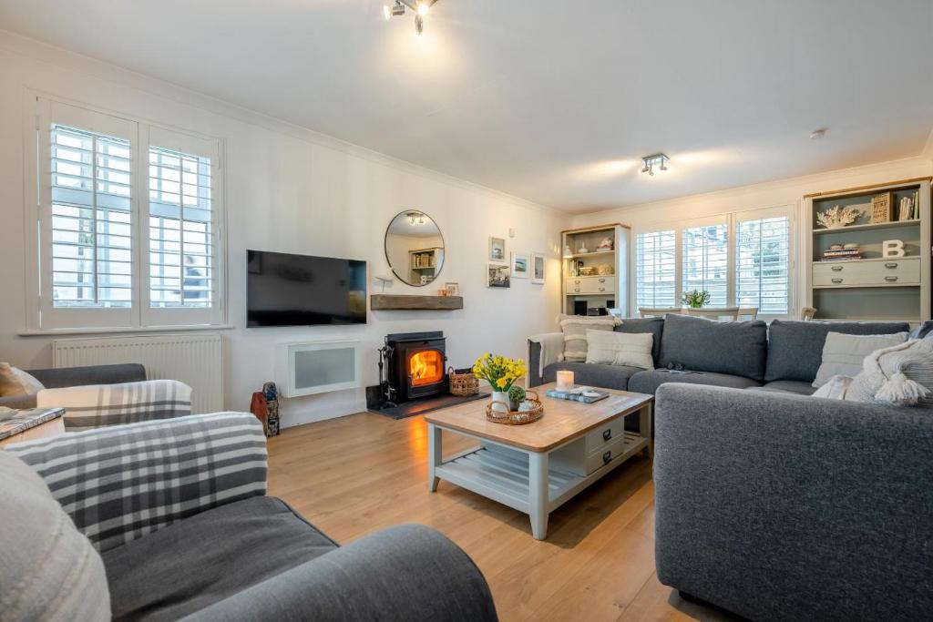 a living room with couches and a fire place at Baxters Cottage in Padstow