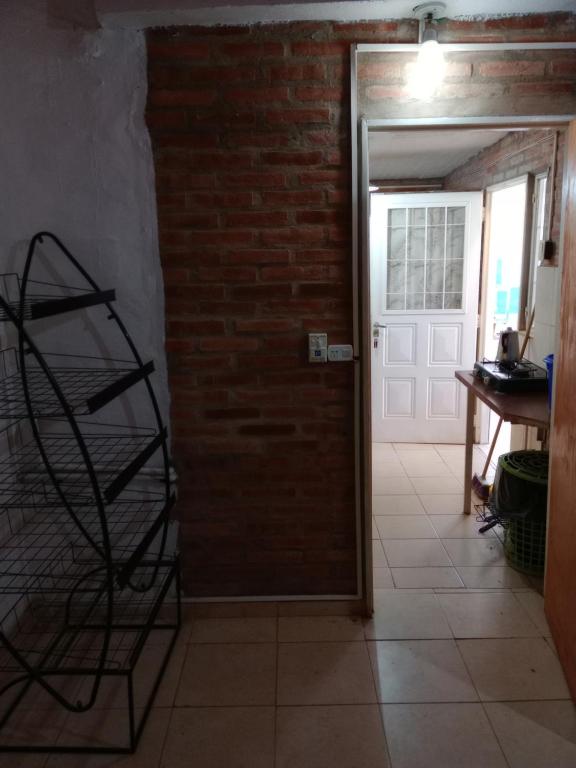 a room with a brick wall and a door at Depto Los Nidos 4 o 5 personas in Villa Cura Brochero