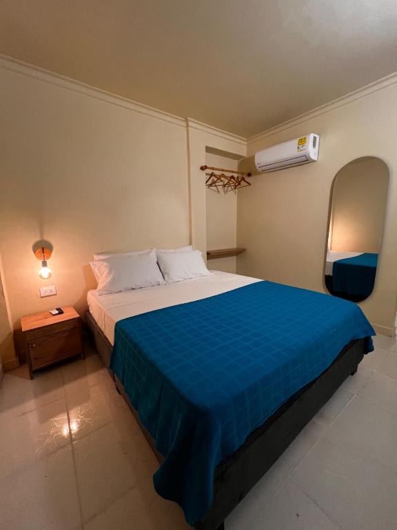 a bedroom with a large bed with a blue blanket at Alma Del Mar in Cartagena de Indias