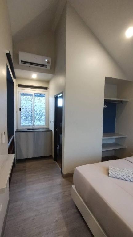 a large room with a bed and a window at บ้านอิ่มสุข in Ban Bua Phut