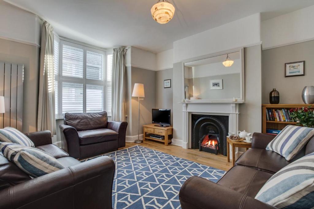 a living room with a couch and a fireplace at Kittiwake Padstow in Padstow