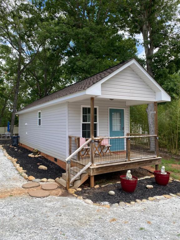un piccolo cottage bianco con un grande terrazzo di Frog Hollow a Townville