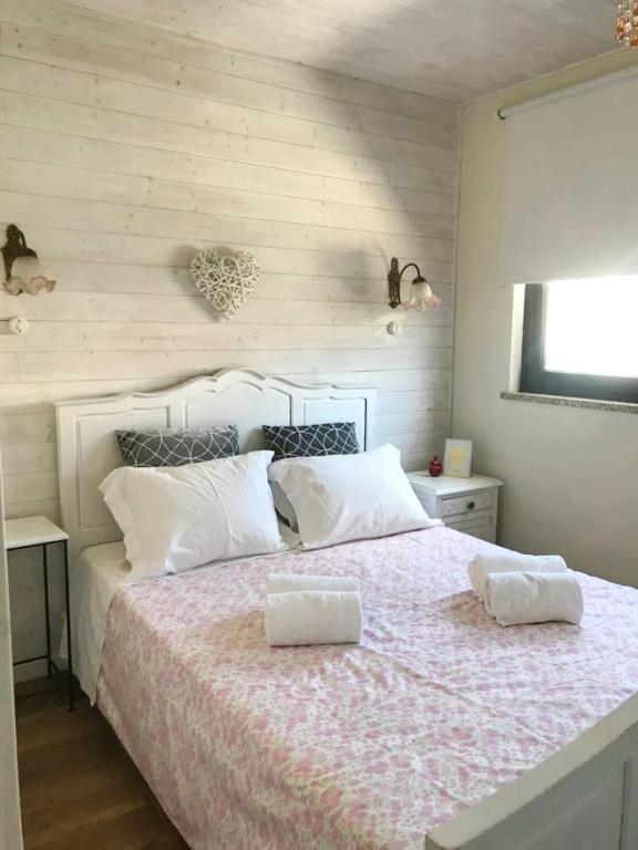 a bedroom with a large bed with two white pillows at Casa da Ponte in São Pedro do Sul
