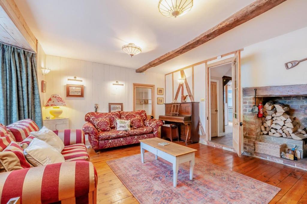a living room with a couch and a fireplace at Malt Shovel House in Sandwich