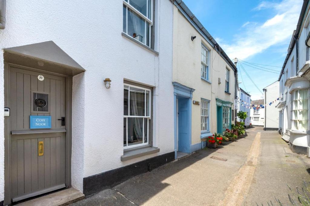 a narrow alley with white buildings and a door at Cosy Nook in Appledore
