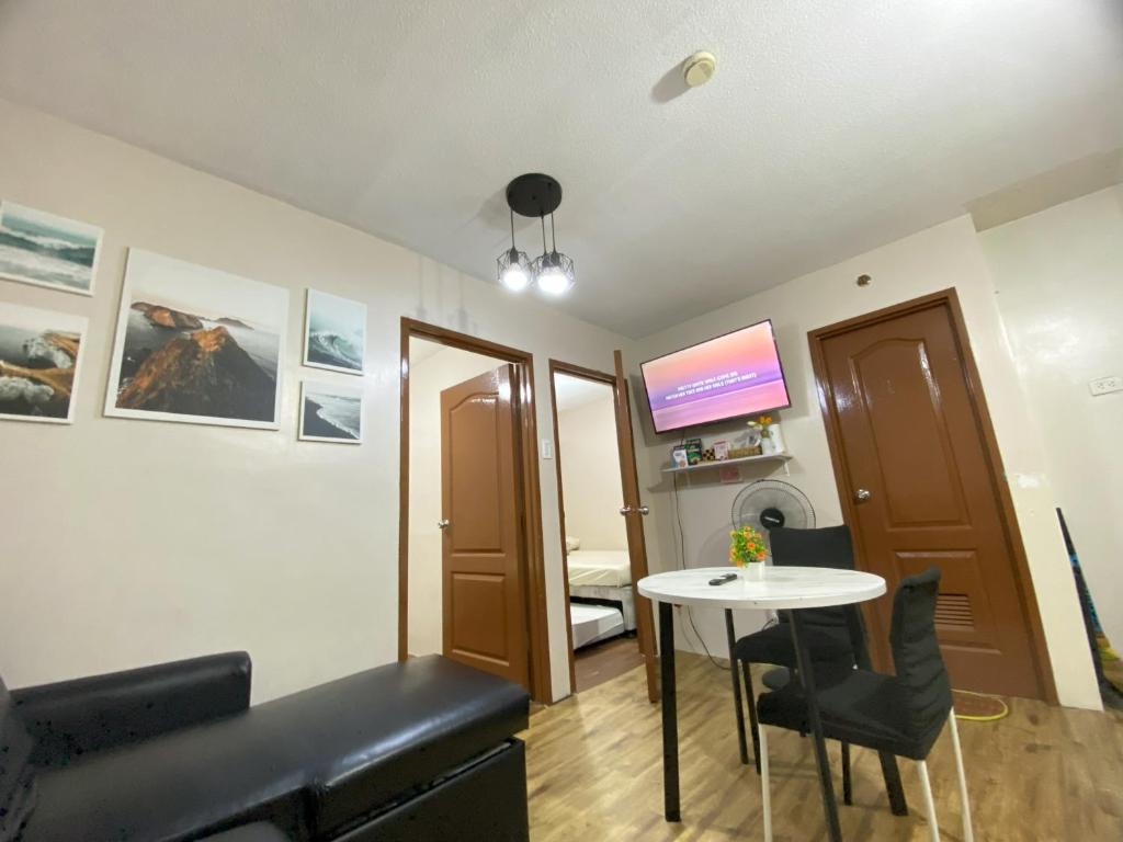 a living room with a table and a tv at Spacious Condo Staycation in Pasig City in Manila