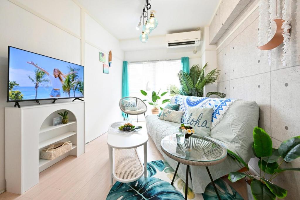a living room with a couch and a tv at アロハベース in Takamatsu