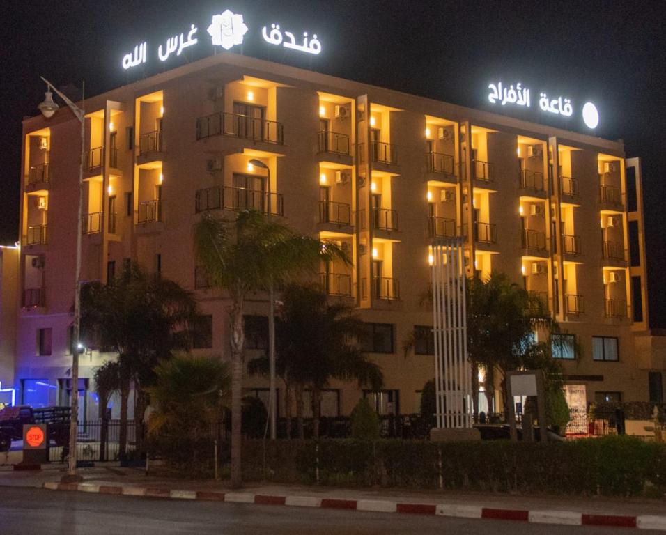 a large building with lights on it at night at Hotel Rherssllah 