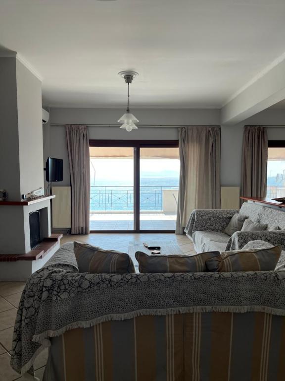 a bedroom with a large bed and a large window at Όμορφο διαμέρισμα με εκπληκτική θέα in Menídion