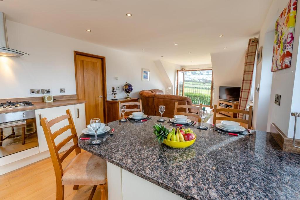 a kitchen and living room with a table with fruit on the counter at Marazion Sail Loft in Marazion