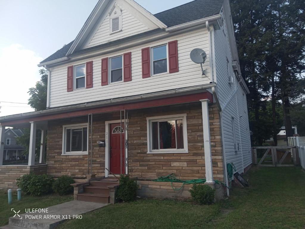 a house with red shutters and a red door at Large downtown home in Philipsburg