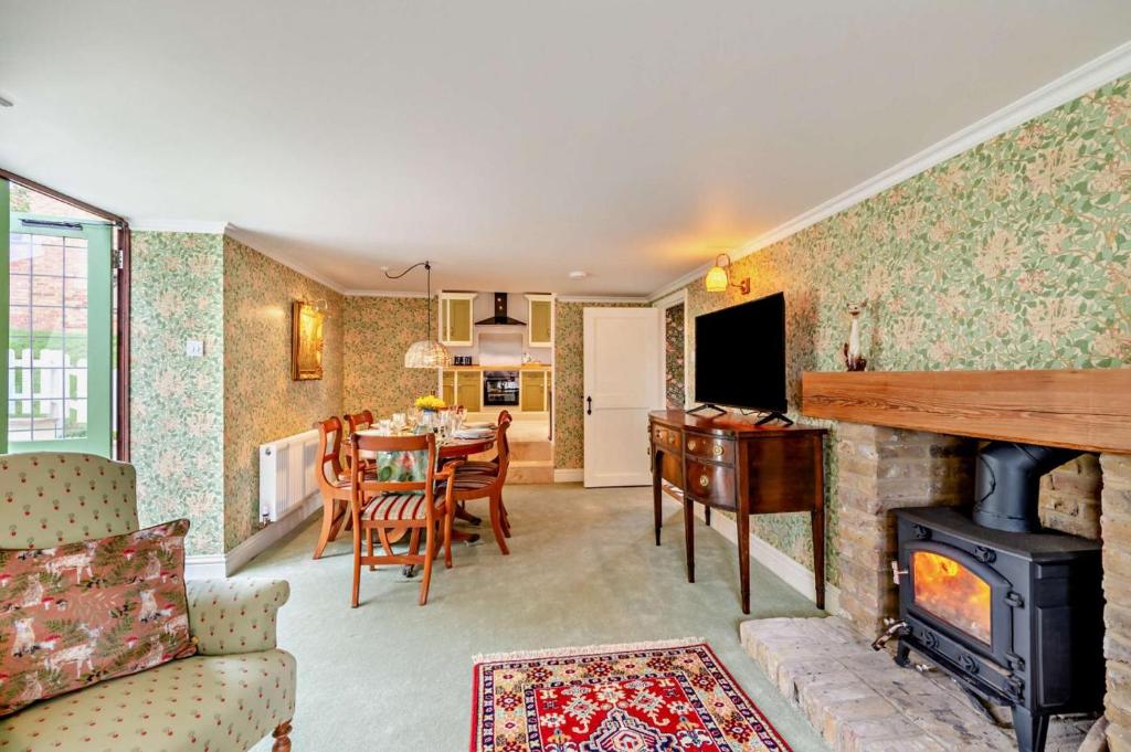 a living room with a fireplace and a dining room at Prospect Villa in Minster