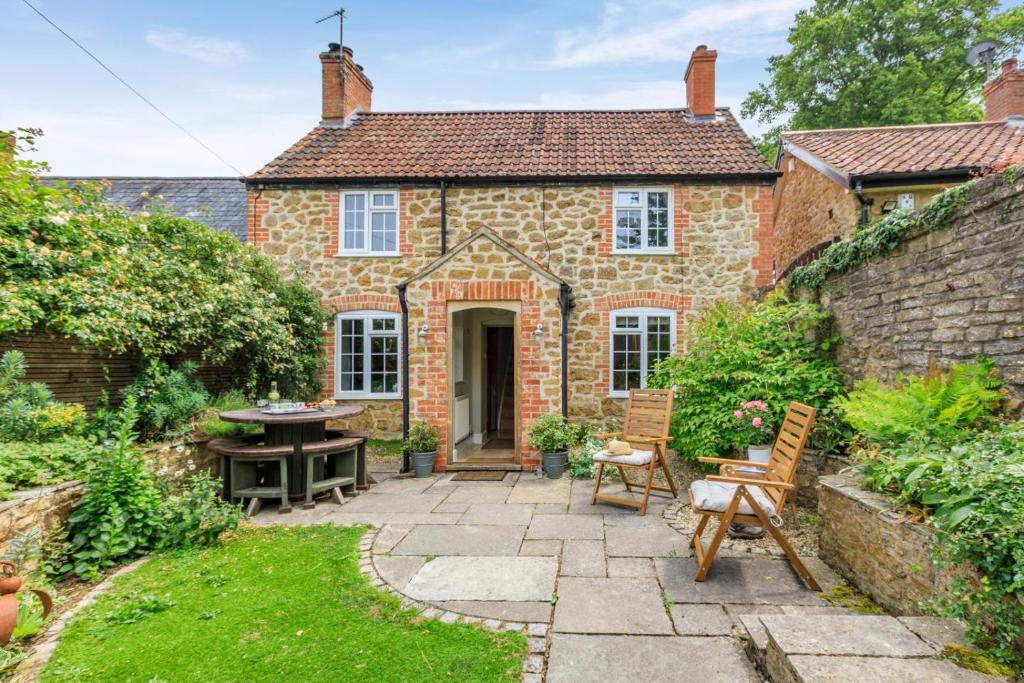 an exterior view of a brick house with a patio at Bonnings Cottage in Barrington