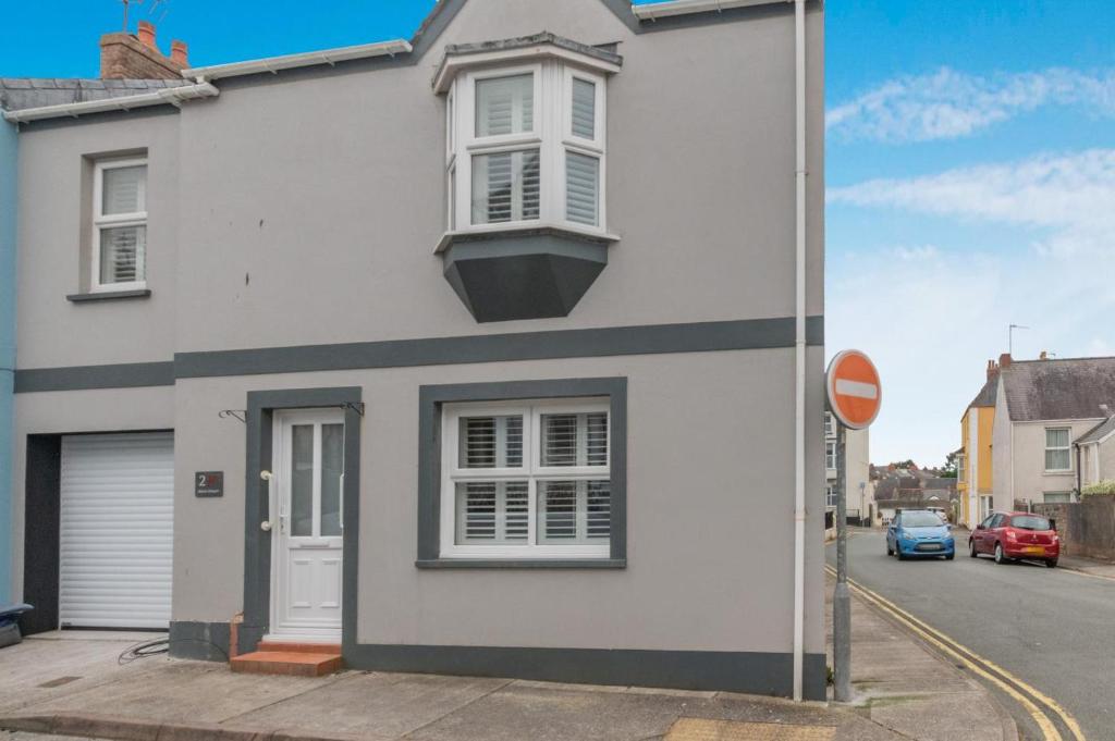 a white house with a window on a street at Mays Place in Tenby