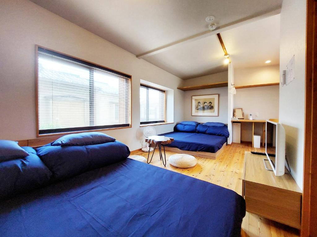 - un salon avec un lit bleu et un canapé dans l'établissement Kamogawa Sanpo, à Shimmachidōri