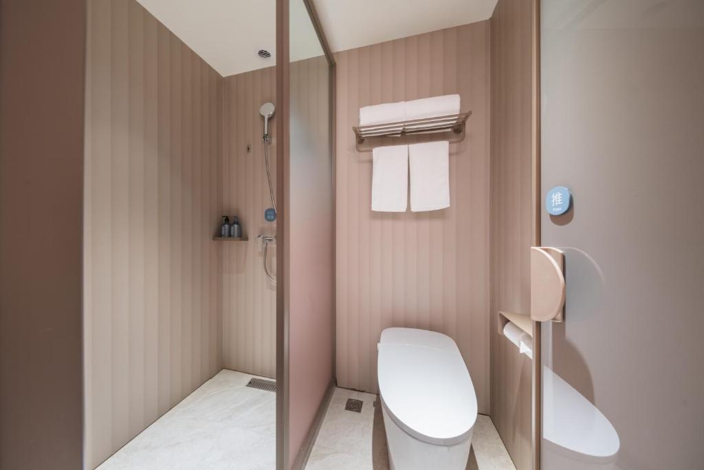 a small bathroom with a toilet and a shower at Hanting Hotel Beijing Zhongguancun Changchun Bridge Subway Station in Beijing