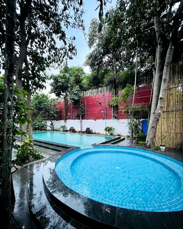 a swimming pool in the middle of a yard with trees at Holy Villa in Kampot