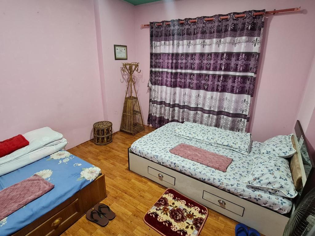 a bedroom with two beds and a window at Room in Kapan, Near Boudhanath Stupa in Kathmandu