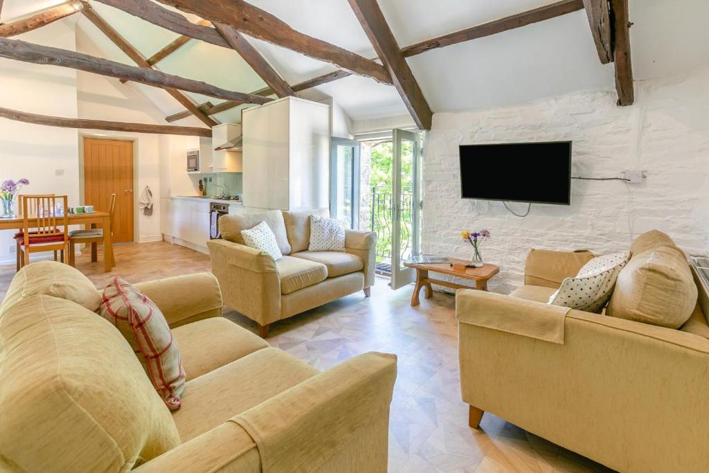 LewannickにあるThe Lambs Barnのソファと薄型テレビのあるリビングルーム