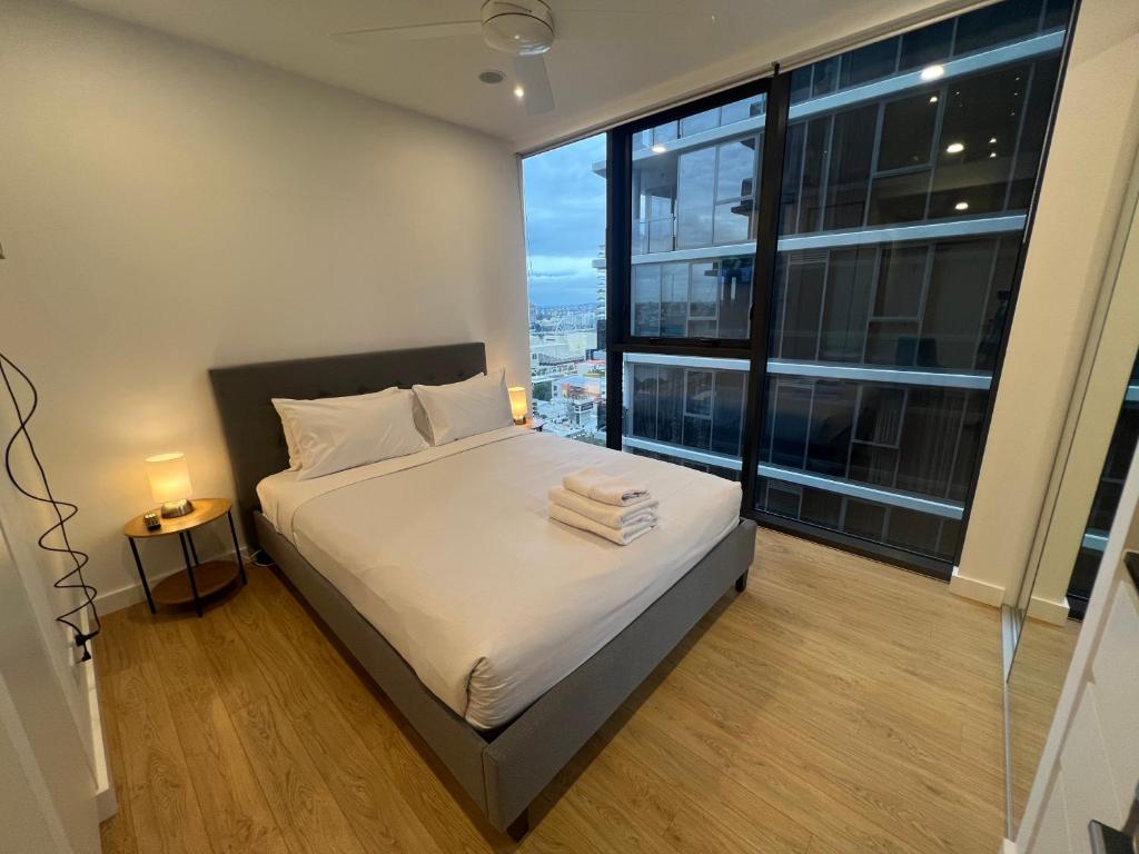 a bedroom with a bed and a large window at Central Located Cozy Studio in South Brisbane in Brisbane