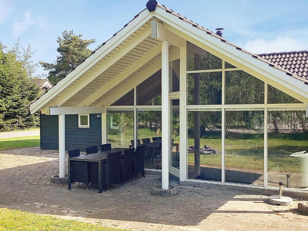 a screened in porch with a picnic table and large windows at 10 person holiday home in Væggerløse-By Traum in Marielyst