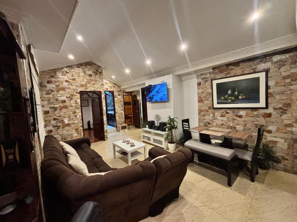 a living room with a couch and a dining room at Apartamento de lujo con sauna a solo 10 minutos del Aeropuerto El Dorado in Bogotá