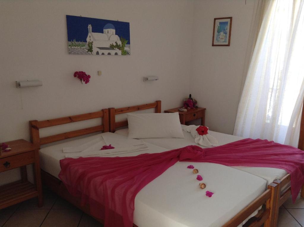 a bedroom with two beds with flowers on them at Arian Hotel in Parikia