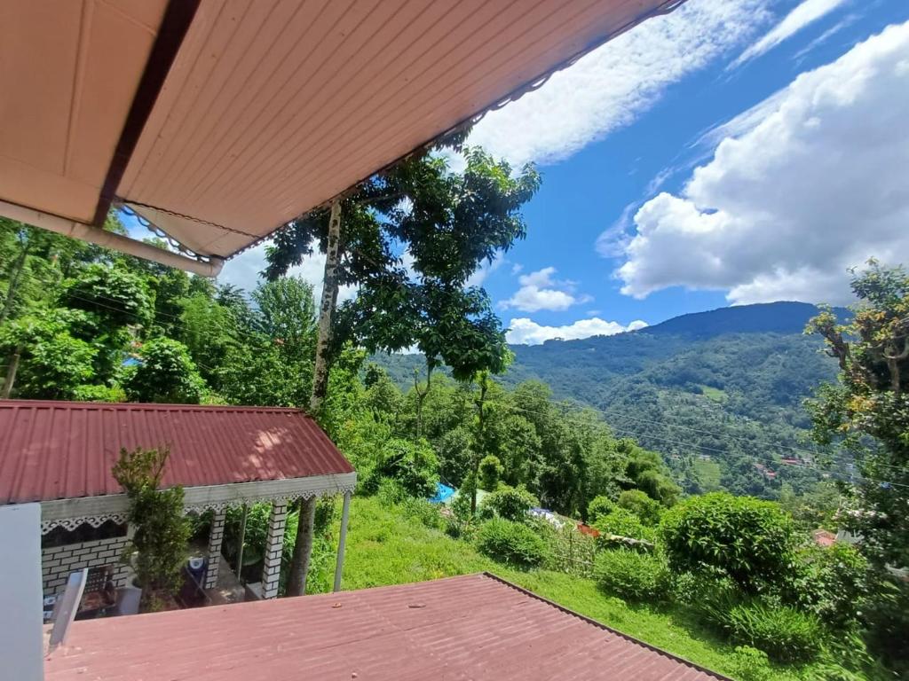 Blick auf die Berge von der Veranda eines Hauses in der Unterkunft Zambala Garden Resort in Gangtok
