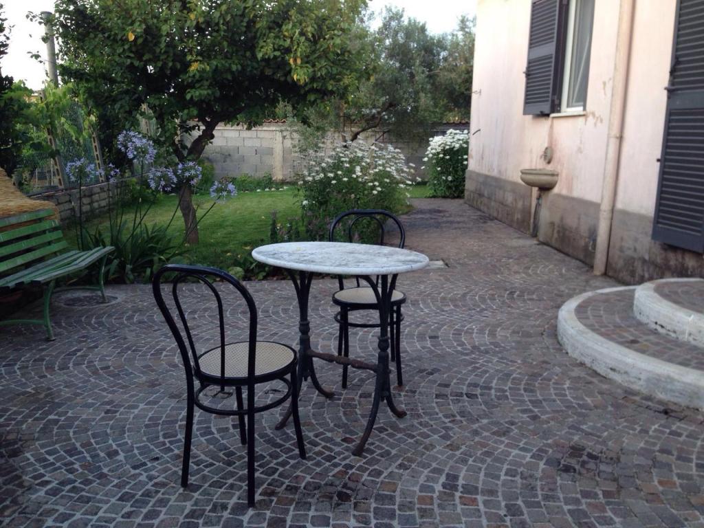 un tavolo e due sedie su un patio in mattoni di Villa Pierina ad Ardea