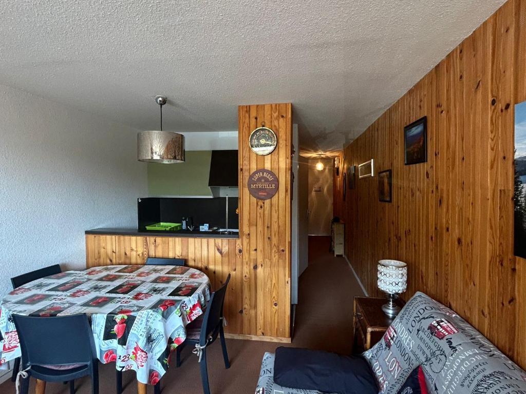 ein Zimmer mit einem Bett und einem Tisch und Stühlen in der Unterkunft Appartement au pied des pistes à Super Besse - FR-1-814-61 in Besse-et-Saint-Anastaise