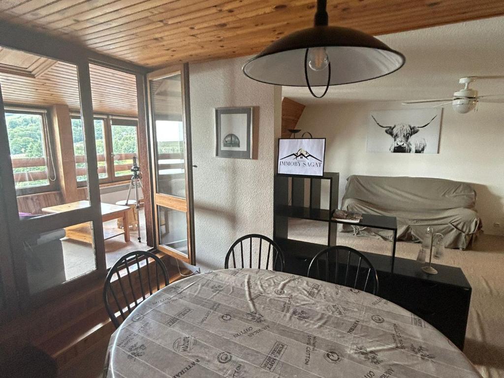ein Esszimmer mit einem Tisch und ein Zimmer mit einem Bett in der Unterkunft Appartement spacieux en montagne avec loggia, au cœur de la station, proche piste et lac - FR-1-814-62 in Besse-et-Saint-Anastaise