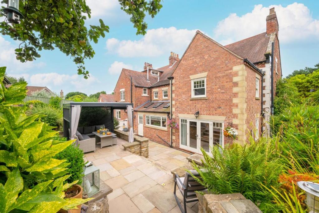 an exterior view of a brick house with a patio at Church Beck Retreat in Scalby