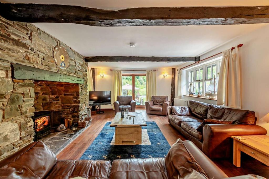 a living room with a couch and a stone fireplace at Barnacle in Bucks Mills