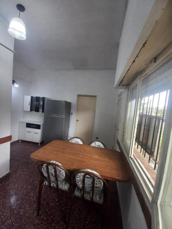 a kitchen with a wooden table and chairs in a room at Alquiler en las Toninas a 2 cuadras del mar in Las Toninas