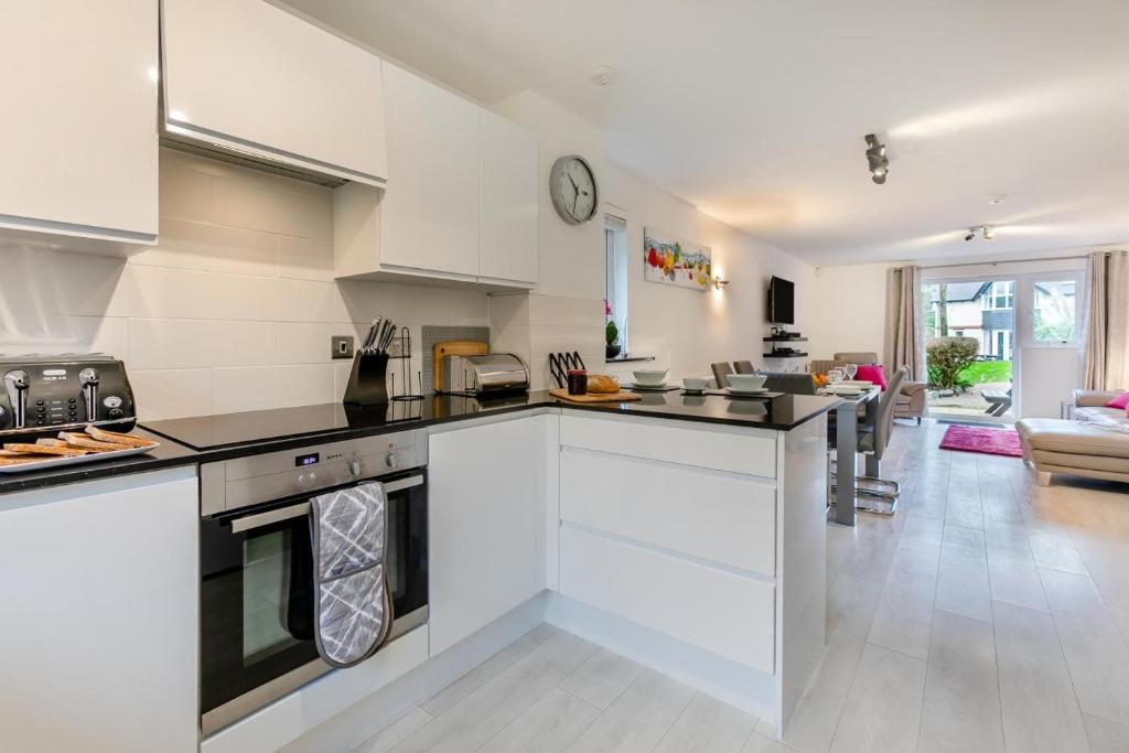卡比斯贝Chapelporth - St Ives的带白色橱柜的厨房和客厅