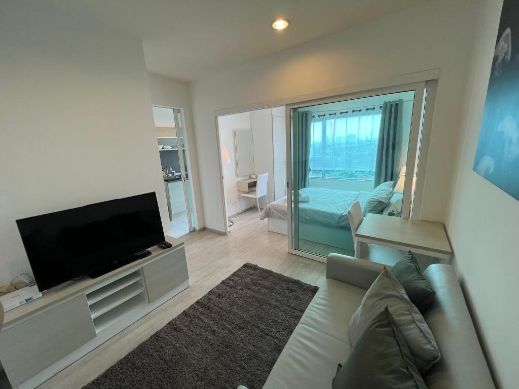 ein Wohnzimmer mit Couch und Flachbildfernseher in der Unterkunft Cozy6 Living in Bangkok 60m to MRT near chatuchank in Ban Bang Khwang