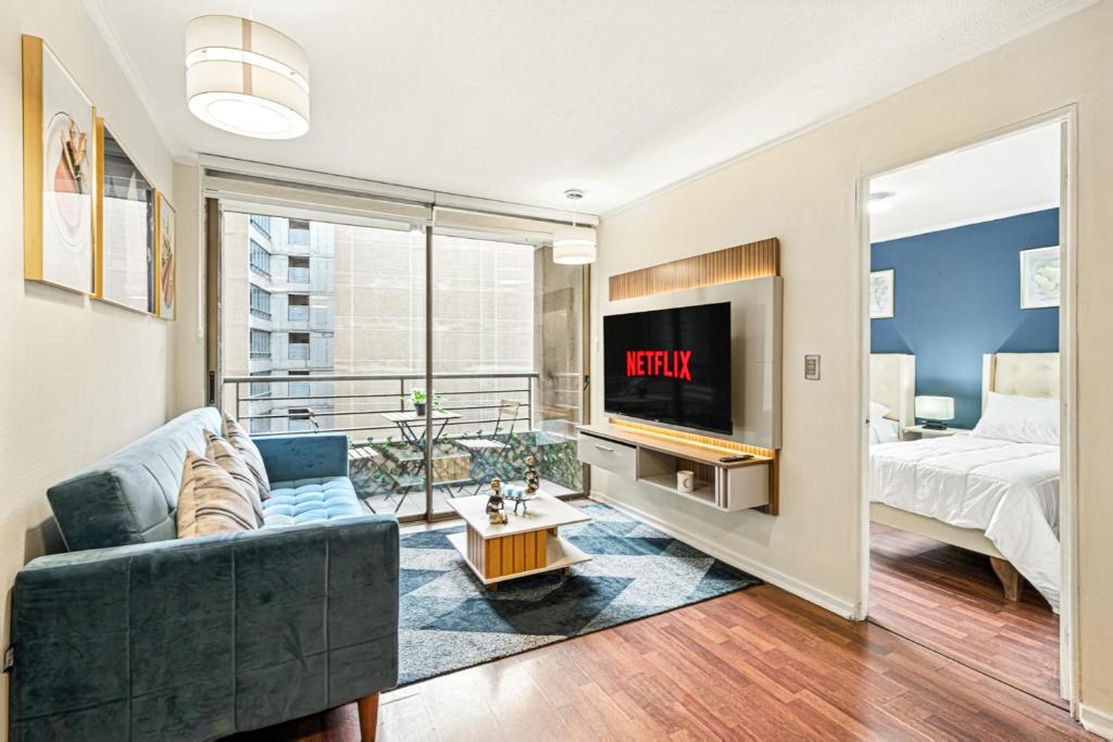 a living room with a couch and a tv at Estreno - Bellas Artes Turístico in Santiago