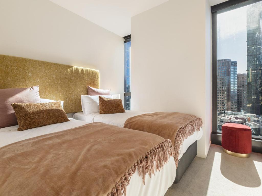 a hotel room with two beds and a large window at Matilda's Skyview - Luxe 2BR, 2BA Near Crown in Melbourne