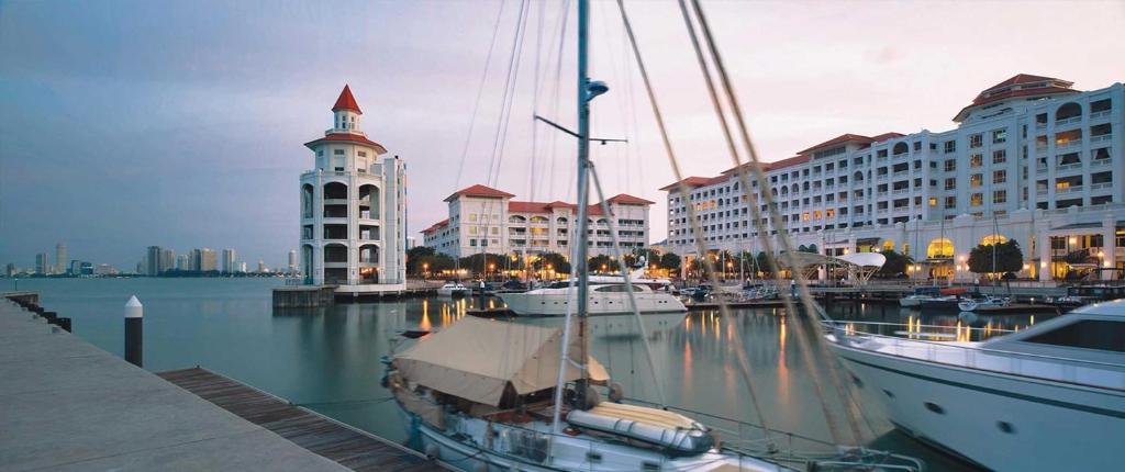 een boot is aangemeerd in een jachthaven met gebouwen bij Marina Suite with Sunrise View in Tanjung Bungah