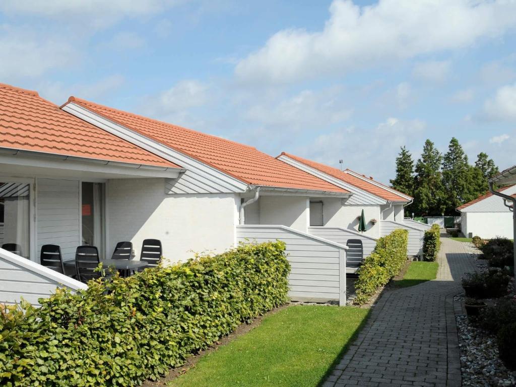 a house with a fence and chairs in the yard at 4 person holiday home in Ærøskøbing-By Traum in Ærøskøbing
