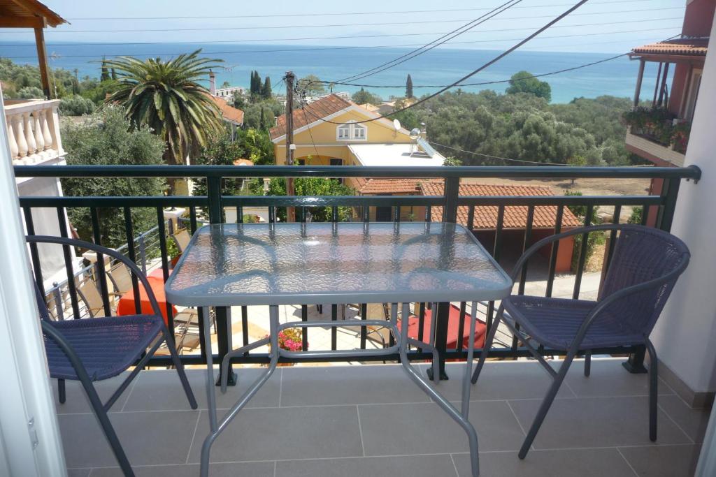 una mesa y sillas en un balcón con vistas en Tassos Village House en Moraitika