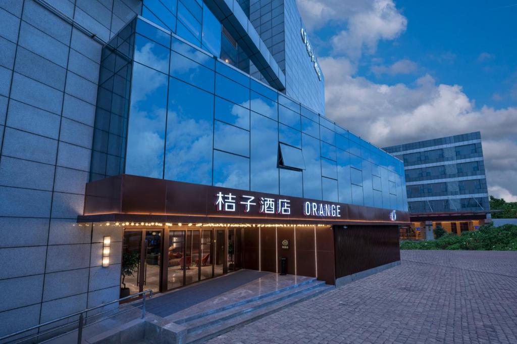 a glass office building with a sign on it at Orange Nanjing Baijia Lake Xiaolongwan Subway Station Hotel in Jiangning