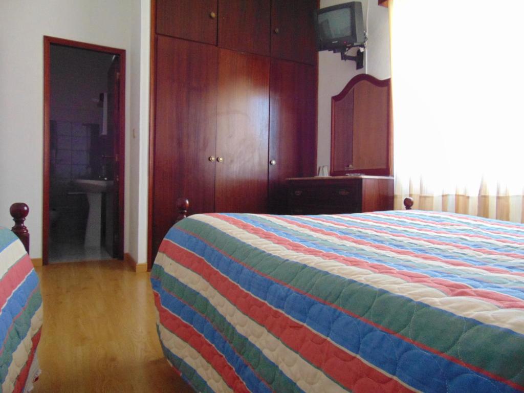 1 dormitorio con 1 cama con una manta colorida en Residencia Beira Baixa, en Monfortinho